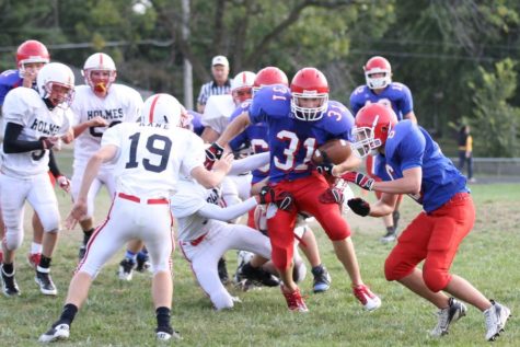 Connor Vincent, '17, runs the ball against the Cedar Falls defense. The Warriors won the game 21-7.