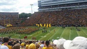 Hawkeye cheerleaders run onto Kinnick Field at a University of Iowa football game in Iowa City.